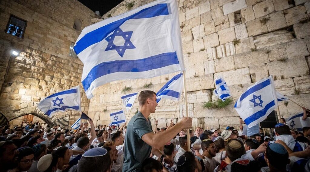 Jewish men dance with Israeli flags at the Western Wall in Jerusalem Old City on the eve of Jerusalem Day, May 9, 2021. Photo by Yonatan Sindel/Flash90 *** Local Caption *** כותל יום ירושלים דגל ישראלי
אלפים
תפילה
בוקר
שחרית
טלית
טליות