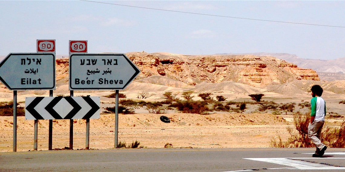 Foto: https://www.flickr.com/people/9269634@N02 / https://commons.wikimedia.org/wiki/File:Directions._Boy_walking_israel_highway_desert_autoroute_beersheva_%282454582241%29.jpg.