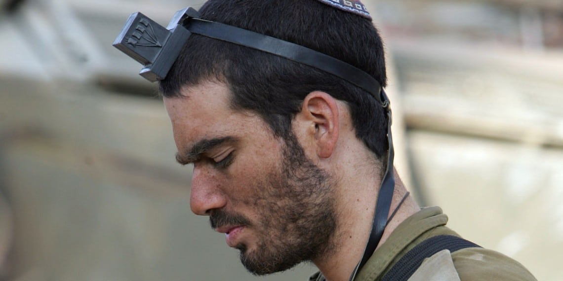 Israelsk soldat i bønn under kamper med terrorister. Foto: https://commons.wikimedia.org/wiki/File:IDF_soldier_kippah_put_on_tefillin-small.jpg.