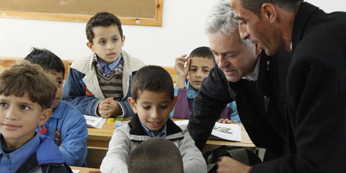 FN driver skoler for hundretusener av palestinske barn på Gazastripen og "Vestbredden". Undervisningsmateriellet er preget av grov antisemittisme og forherligelse av bestialske myrderier på sivile jøder. Foto: DFID - https://commons.wikimedia.org/wiki/File:Alan_Duncan_talking_to_schoolchildren_in_Gaza,_10_December_2012_%288261828844%29.jpg.